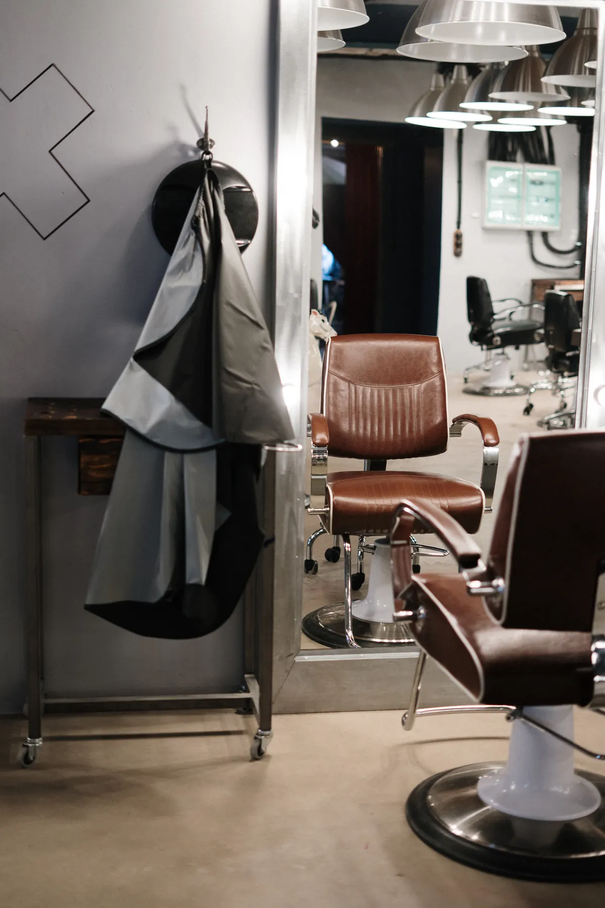Modern barbersalong med läderfåtöljer och spegel